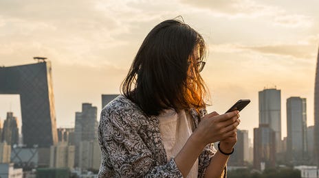 Jovem faz curso de mandarim online pelo celular.