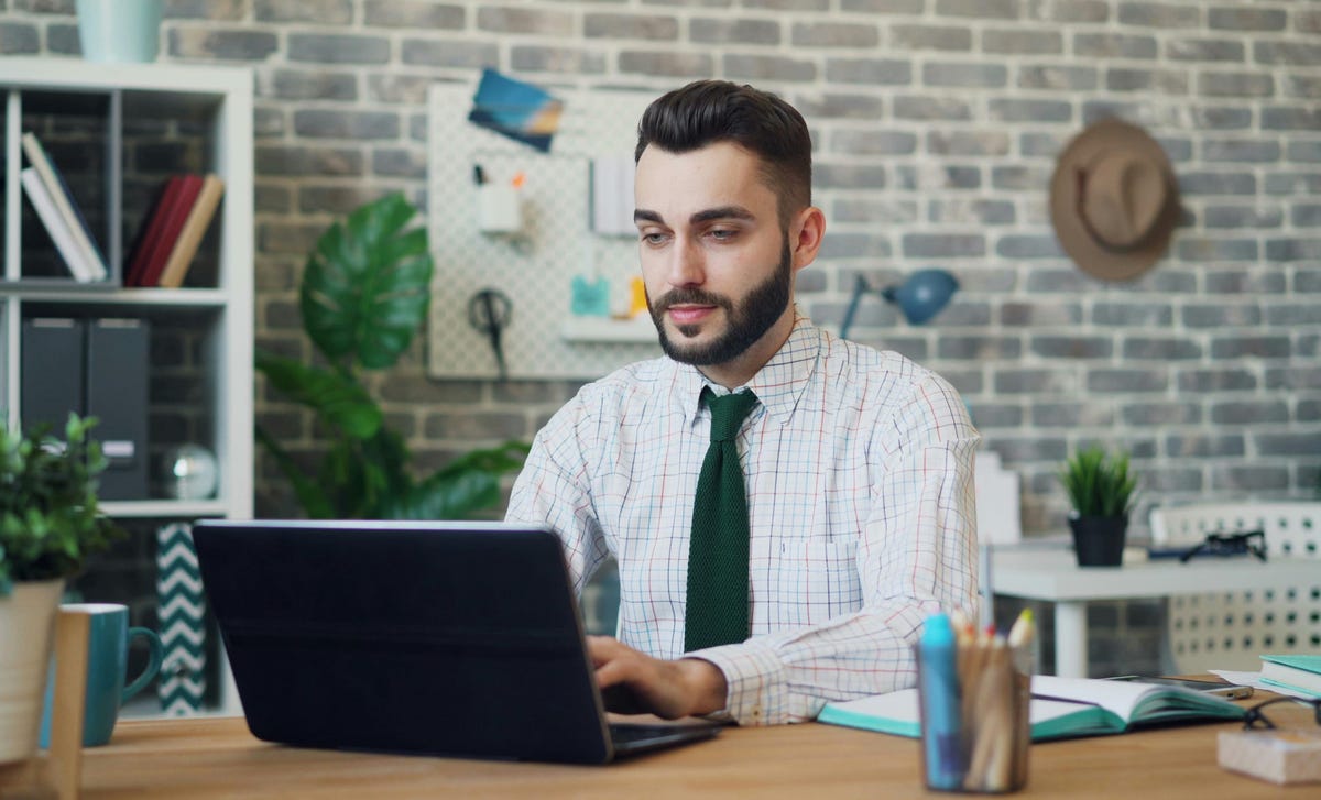 Homem trabalhando tranquilo em seu computador após ter concluído o curso de produtividade digital.