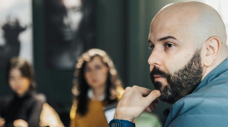Homem sério em uma reunião sobre uma série de treinamentos de soft skills.