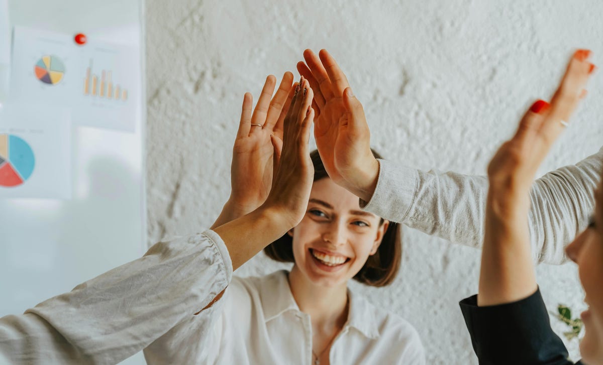 Mulher, que aprendeu sobre influência no trabalho, ganhou apoio dos colegas com um toque de mãos.