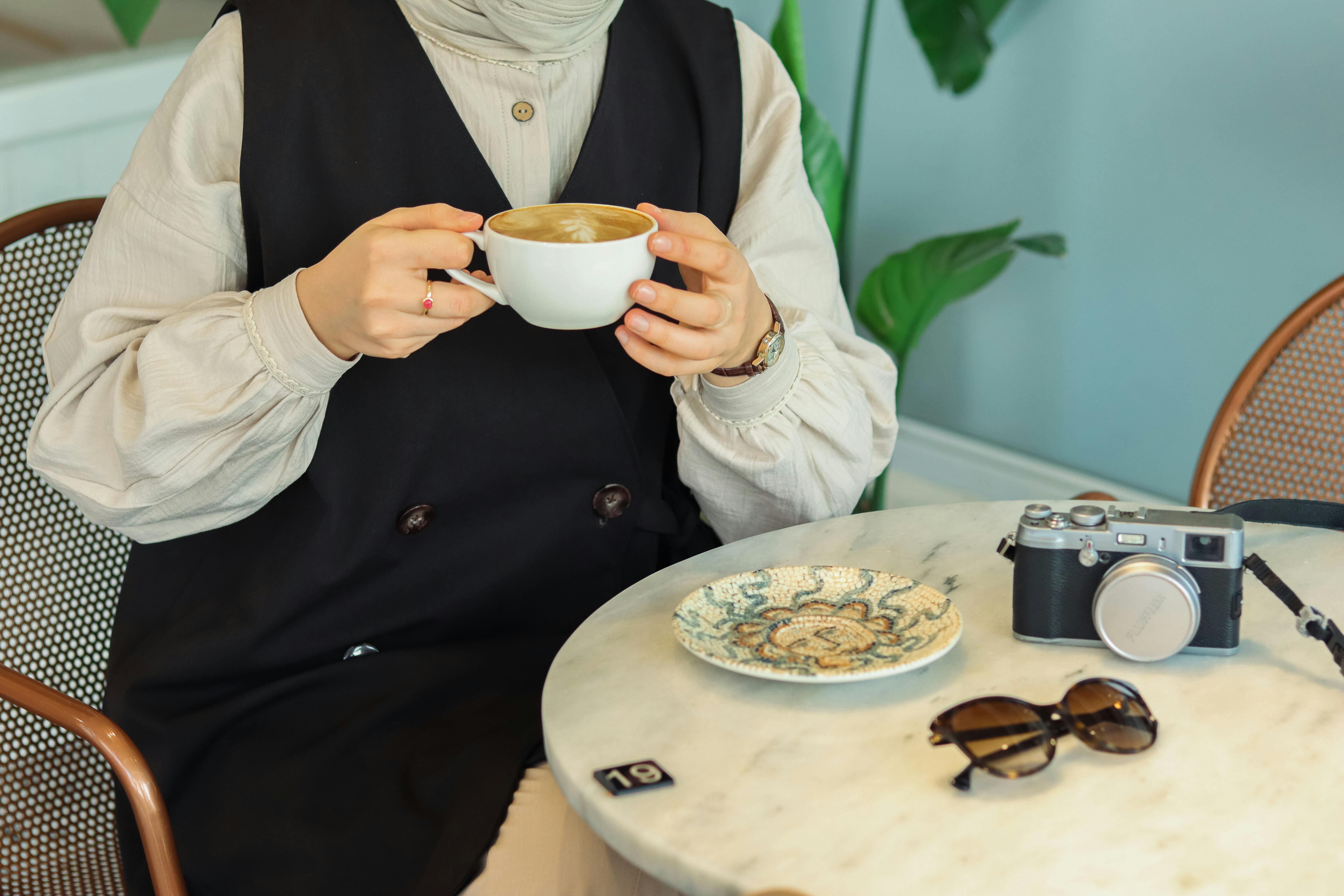 Mulher aprende como falar café em espanhol enquanto toma um cappuccino.