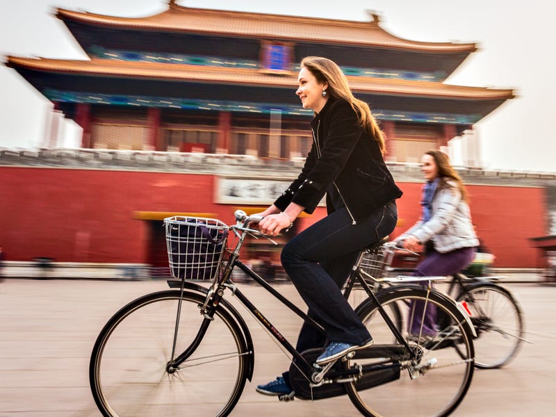 Mulheres passeiam em Pequim após aprender mandarim no Berlitz.