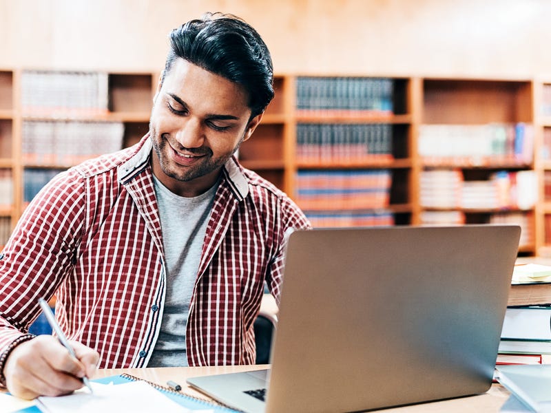 Homem estuda sinônimos em espanhol na biblioteca.