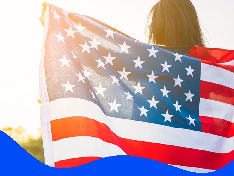 Mulher segurando a bandeira vermelha, azul e branca para representar a cultura dos Estados Unidos.