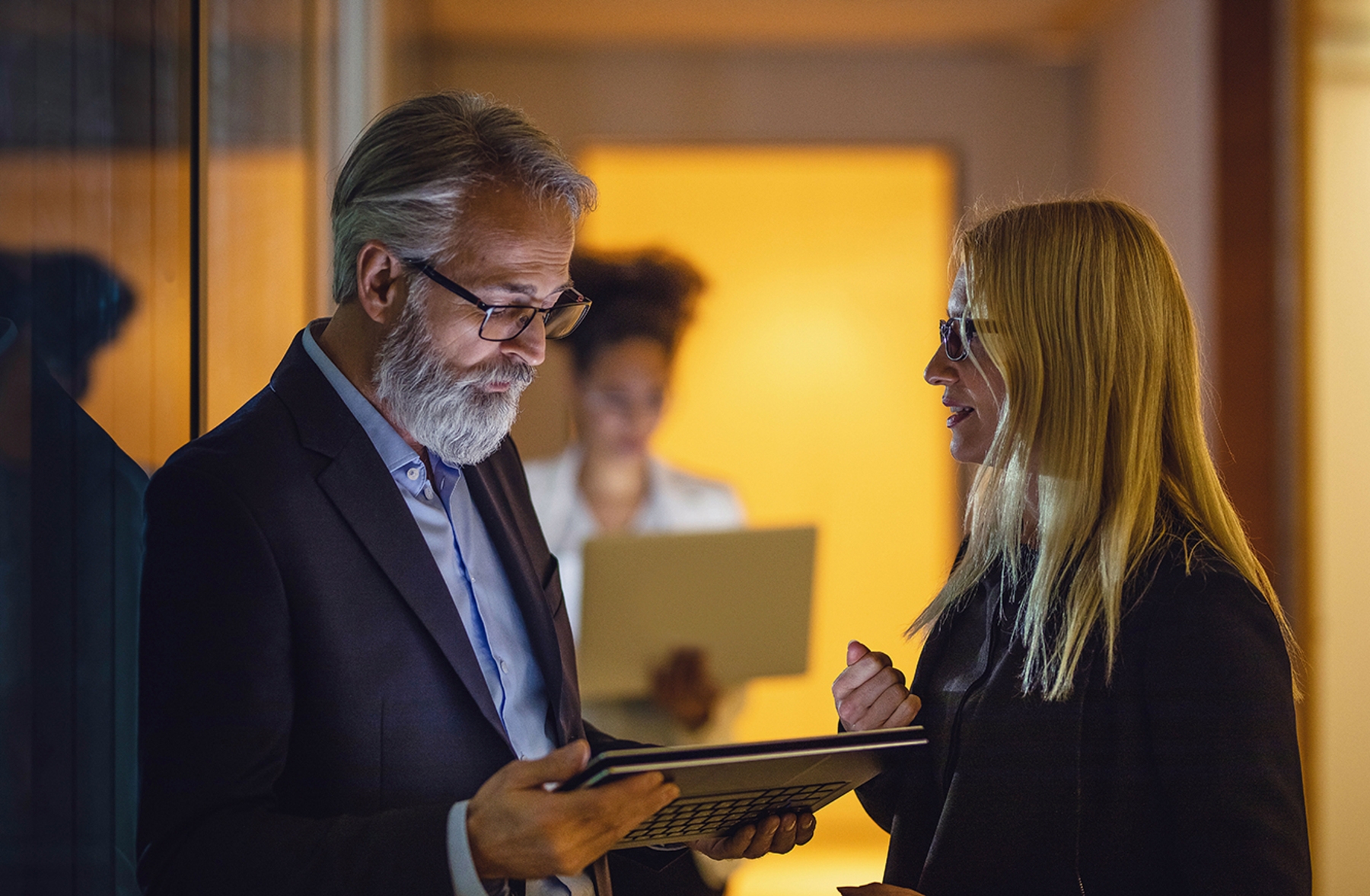 Dois colaboradores conversam no corredor da empresa para tentar melhorar a gestão de conflitos.
