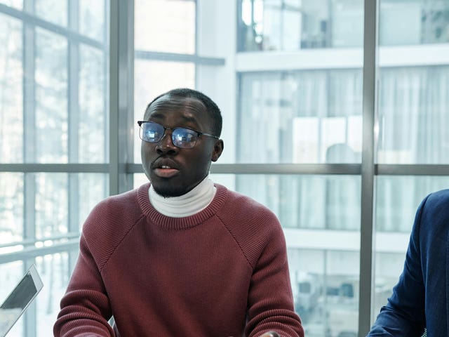 Homem se comunicando com o restante da equipe demonstrando suas habilidades profissionais aprendidas no curso de comunicação.