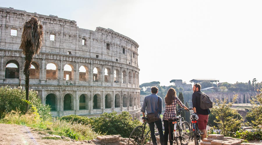 Grupo de três cidadãos italianos andando de bicicleta em Roma, na Itália.