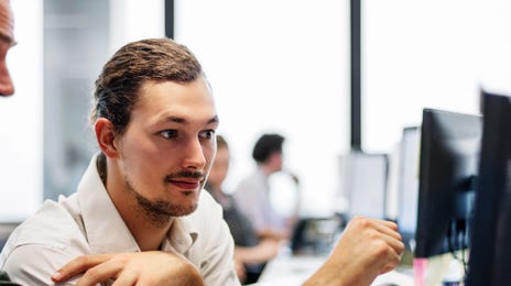 Dois homens mexendo em um computador.