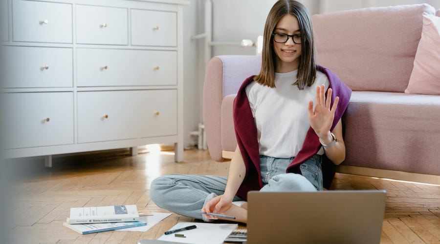 Mulher sentada no chão mexendo no computador enquanto pratica o past perfect.