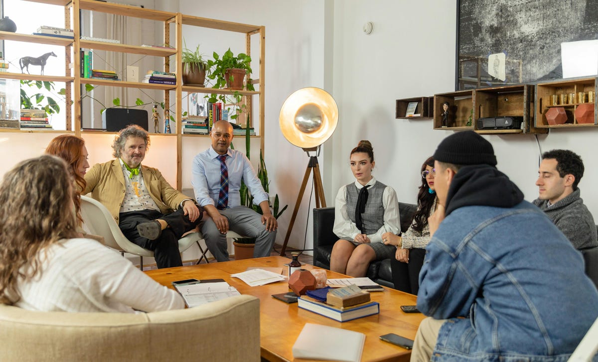 Mulheres e homens reunidos em uma sala, sentados para realizar os cursos de soft skills.