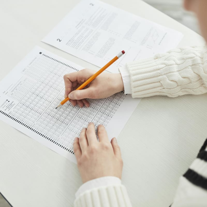 Estudante preenchendo gabarito de teste para responder à pergunta: como saber meu nível de inglês.