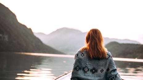 Estudante de inglês sentada em um barco flutuando em um lago no Canadá.