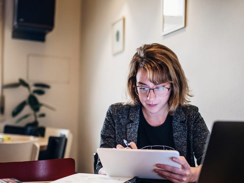 Mulher faz curso de idiomas online em casa pelo computador.