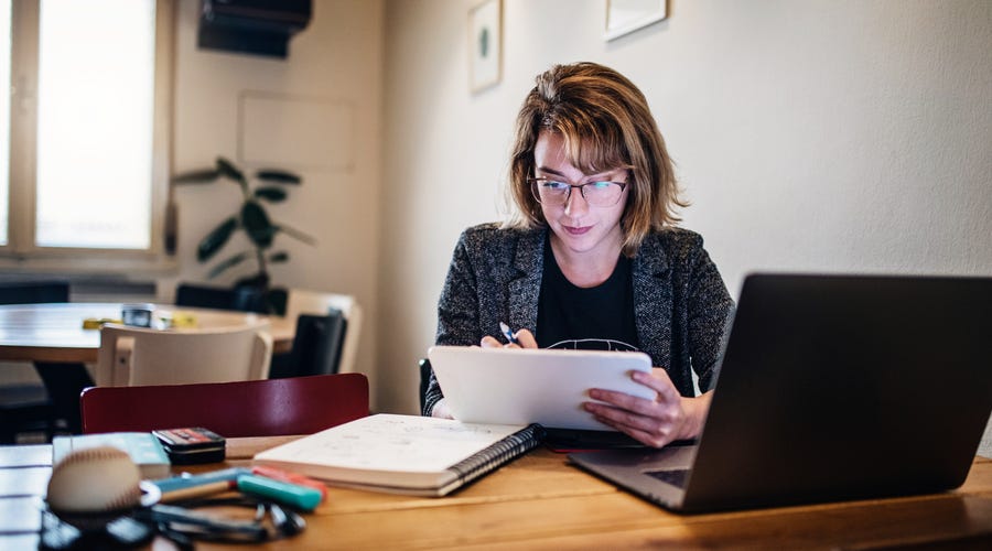 Mulher faz curso de idiomas online em casa pelo computador.