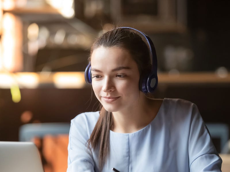 Garota estudante revisando os pronomes possessivos em inglês por meio de computador, sentado em sua sala de estar.