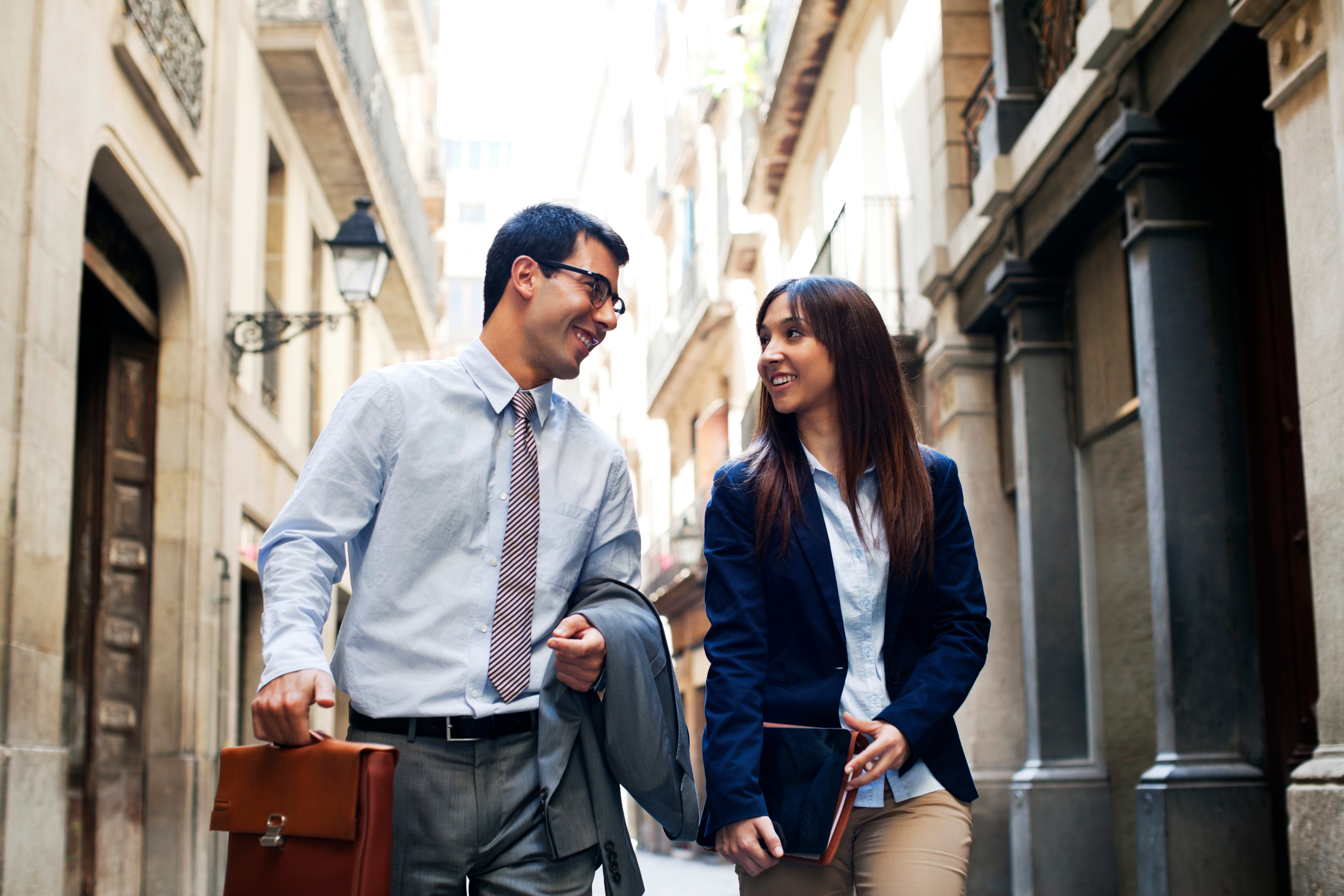 Funcionários que estudam um curso profissional de idiomas conversam sobre ele na saída do trabalho.