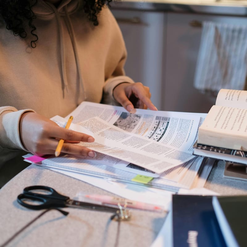 Papéis e livros na mesa sobre o present perfect continuous.