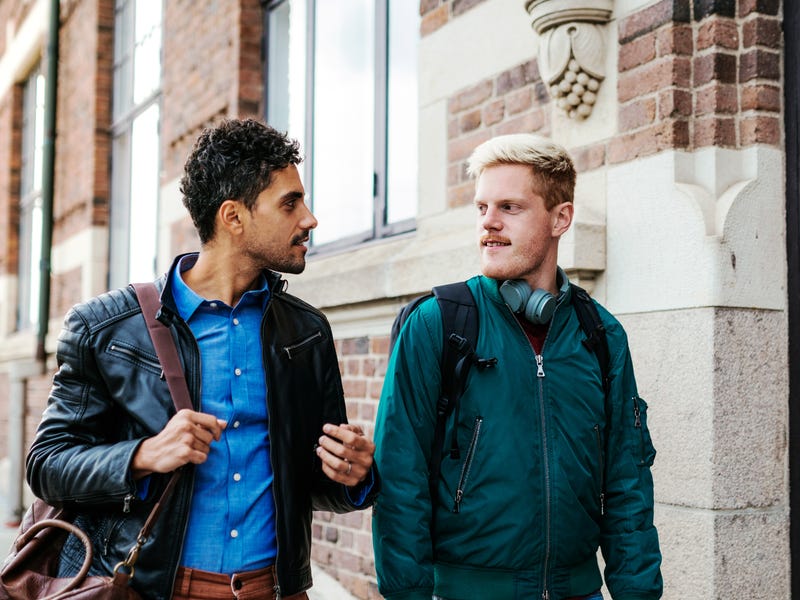 Amigos se cumprimentam em inglês na rua