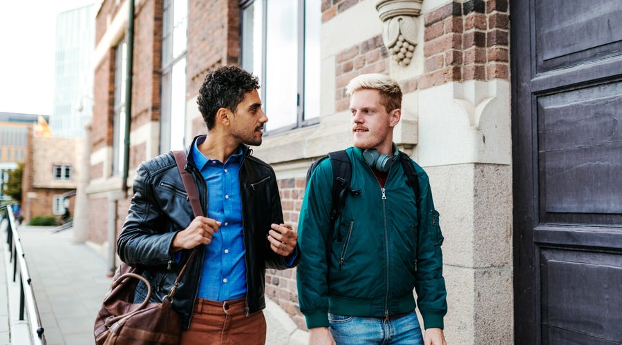 Amigos se cumprimentam em inglês na rua