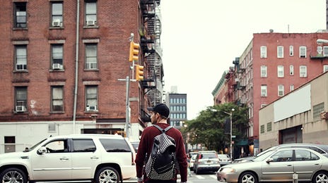 Jovem estudante atravessa faixa de pedestres nos Estados Unidos.