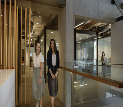 Two people walking together walking through a building.