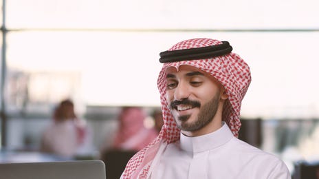 Man attending an online language class with Berlitz Saudi Arabia from his laptop