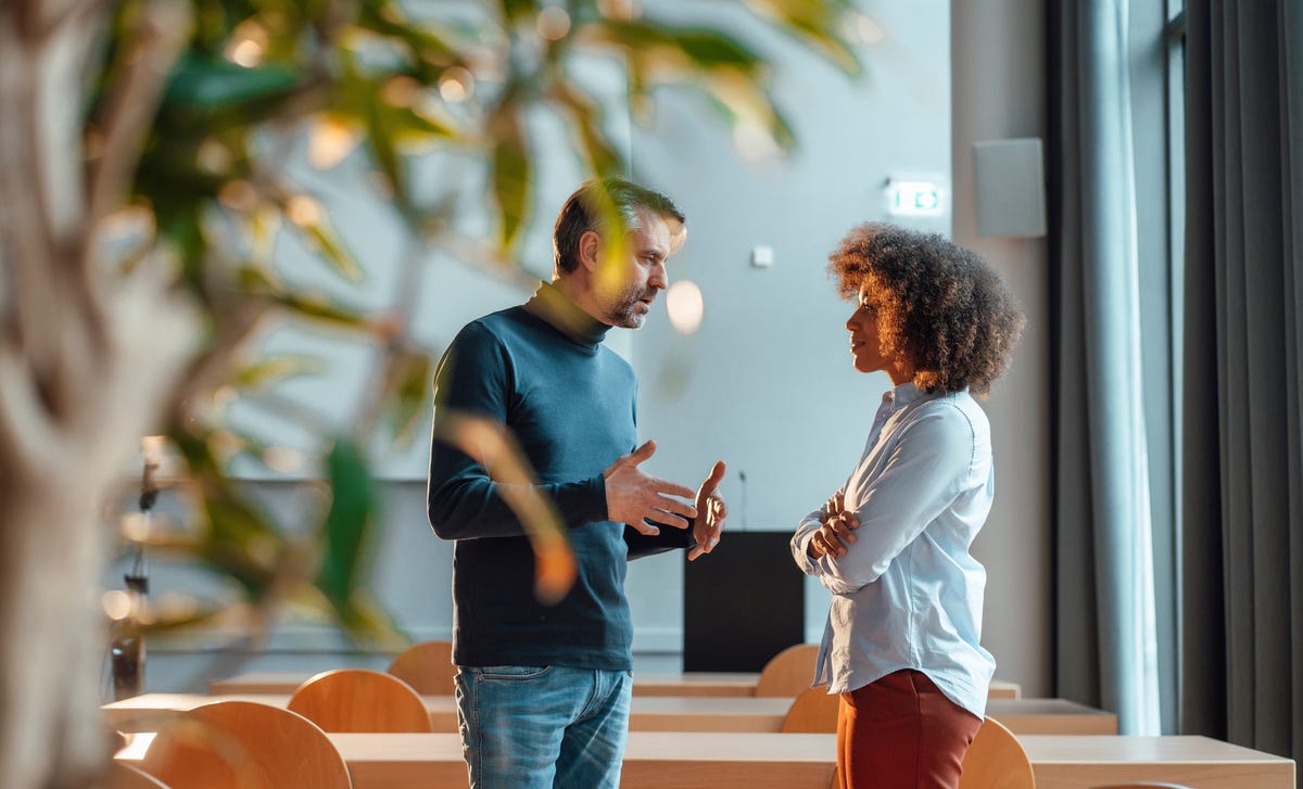 Student and instructor in the classroom chatting with each other after their Italian speaking course