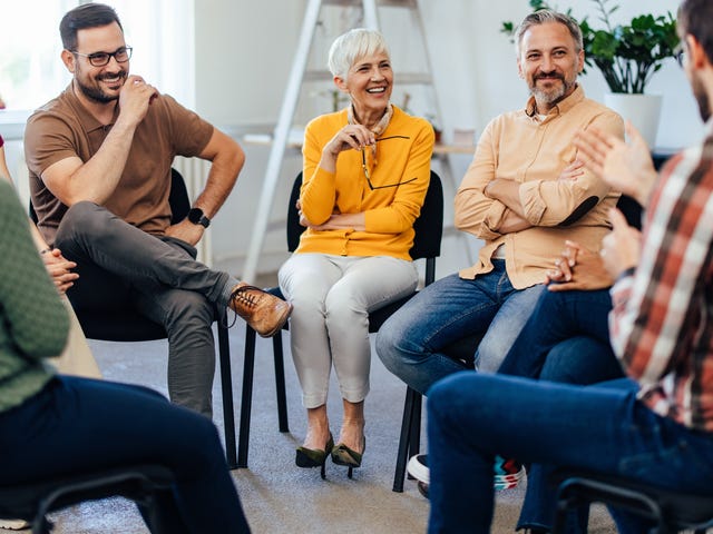 Group of students sitting in a circle and learning a language from their instructor using the Berlitz Method