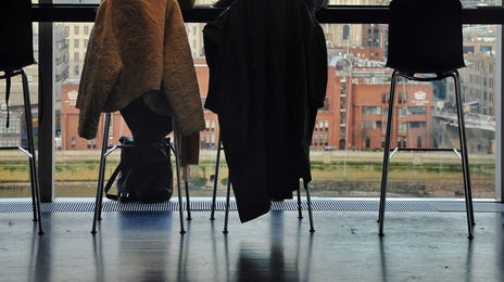 Friends sitting in front of a big window looking out on a city where they went to learn a language abroad