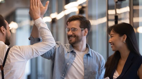 Employees giving each other a high five after after signing up for business language services with Berlitz Saudi Arabia