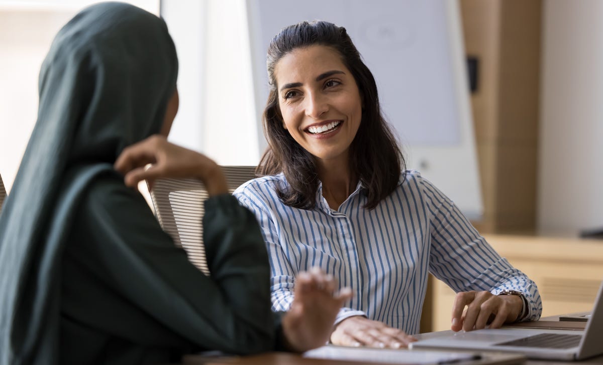 Student and instructor sitting at a table discussing language proficiency levels