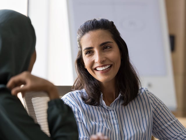 Student and instructor sitting at a table discussing language proficiency levels
