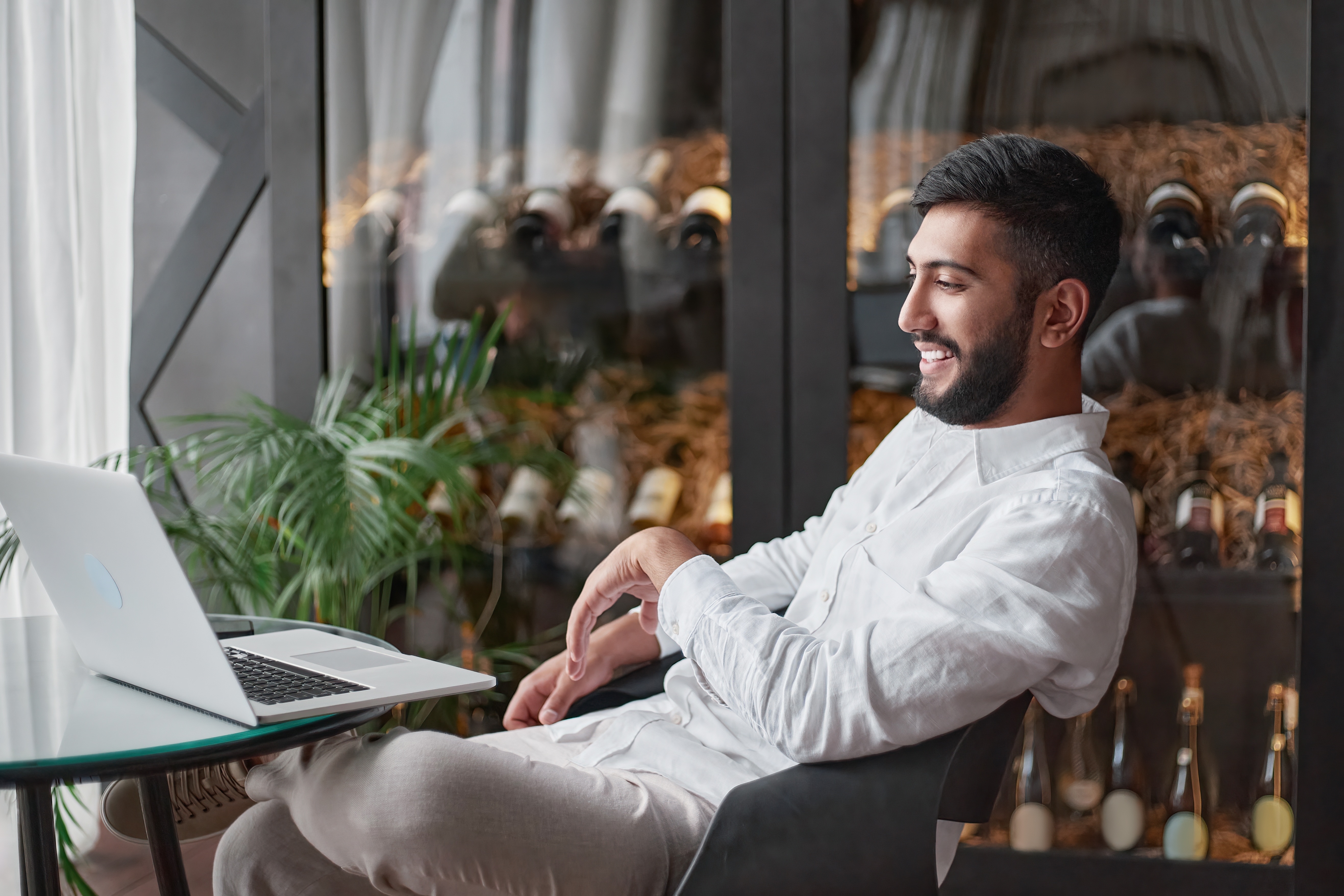 Man smiling while looking at his laptop during his online language courses with Berlitz