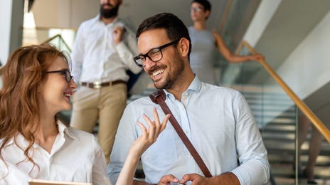 Two employees talking to each other after a meeting and discussing Business English terms