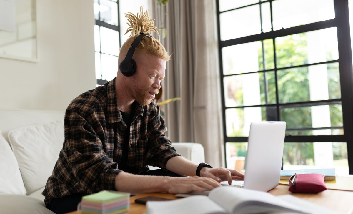 Man in front of a laptop taking notes and elearning languages