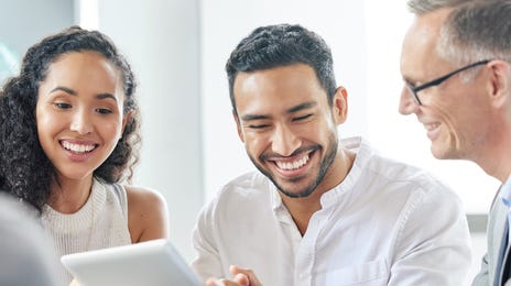 Employees reading a document that was translated by Berlitz Saudi Arabia and smiling