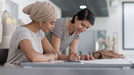Instructor writing in the student's notebook during one of their private language lessons