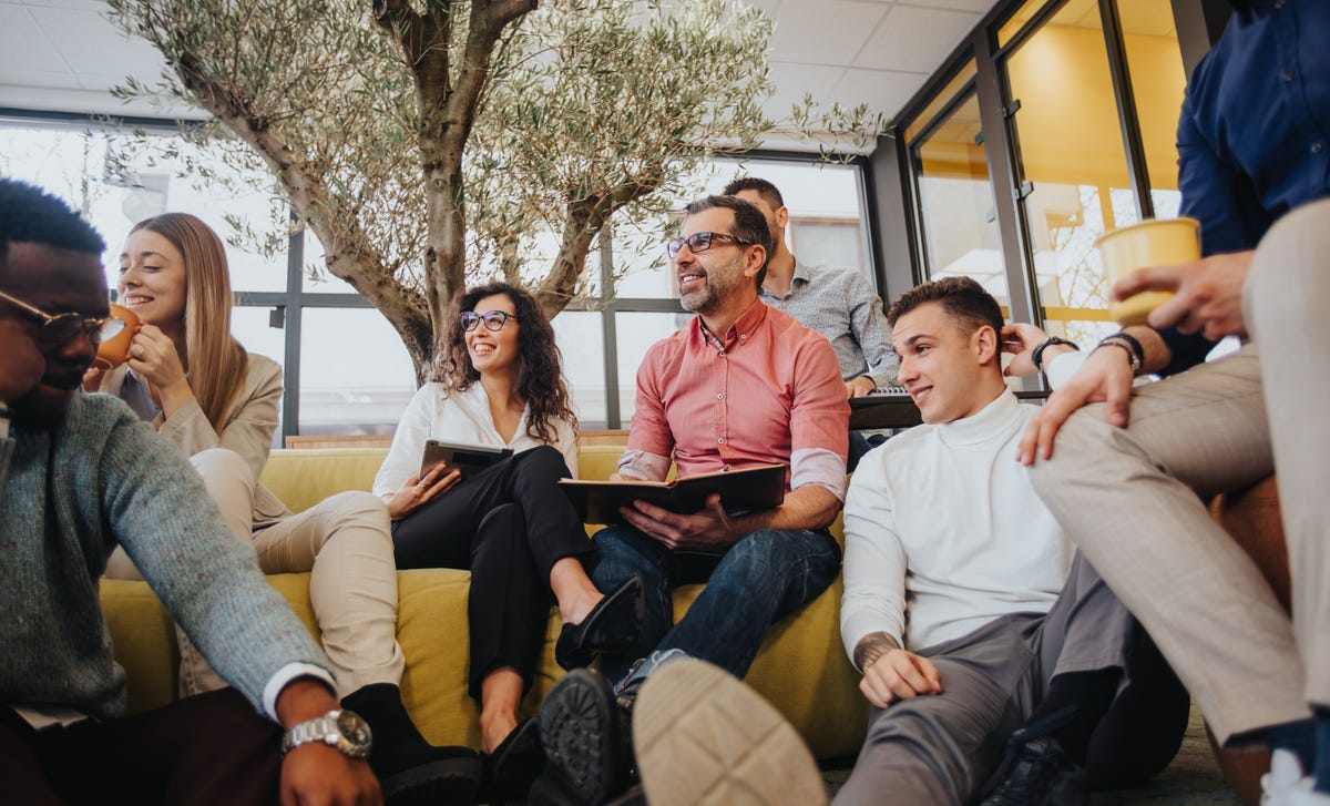 Group of people sitting on and around the couch during a language lesson for adults with Berlitz Saudi Arabia