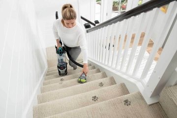 Using hose and tool to vacuum stairs