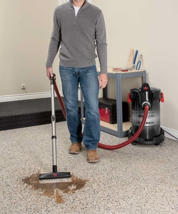 Using Wand with foot to vacuum spill from garage flooring.