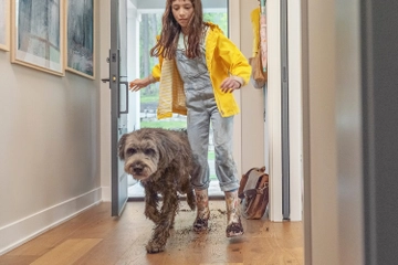 Child and dog running in entry way with muddy feet and paws