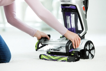 Removing Brush Roll Cover from foot of carpet cleaner.
