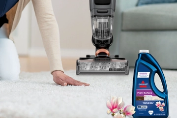 running hand across carpet withe CrossWave and bottle of formula in background