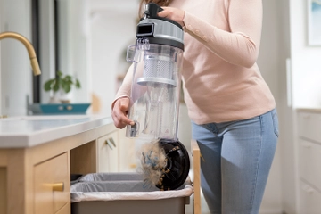 Emptying dirt from dirt bin into trash.