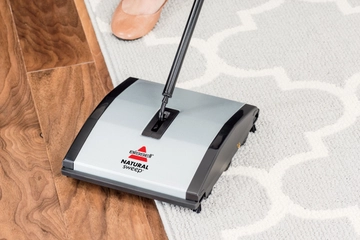 Natural Sweep Manual Sweeper picks up dirt on hard floor and area rug 