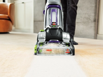 Using CleanShot Pretreater on foot to spray stain on carpet.
