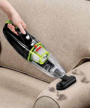 Using Pet Hair Eraser Hand Vac Dusting Brush to vacuum pet hair off arm of chair.