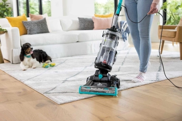 CleanView Swivel Pet Reach Vacuum moving from area rug to hard flooring.