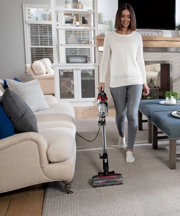 CleanView Pet Slim Corded Stick Vac Vacuuming area rug.