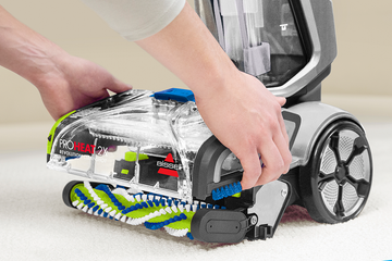 Removing Brush Roll Cover from foot of carpet cleaner.